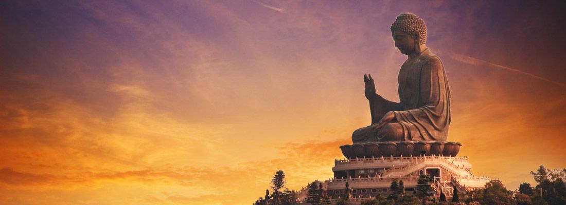 Il Buddha di Po Lin al tramonto, con un bellissimo cielo arancione e viola.