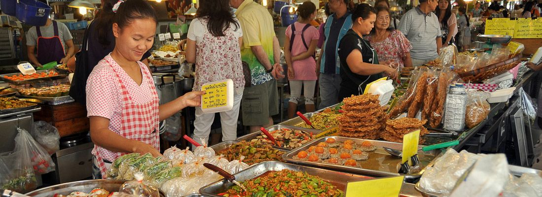 Una signora vende cibo al Chatuchak Market di Bangkok.