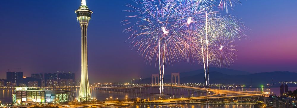 Fuochi d'artificio sopra la Torre di Macao e il ponte Sai Van di notte.
