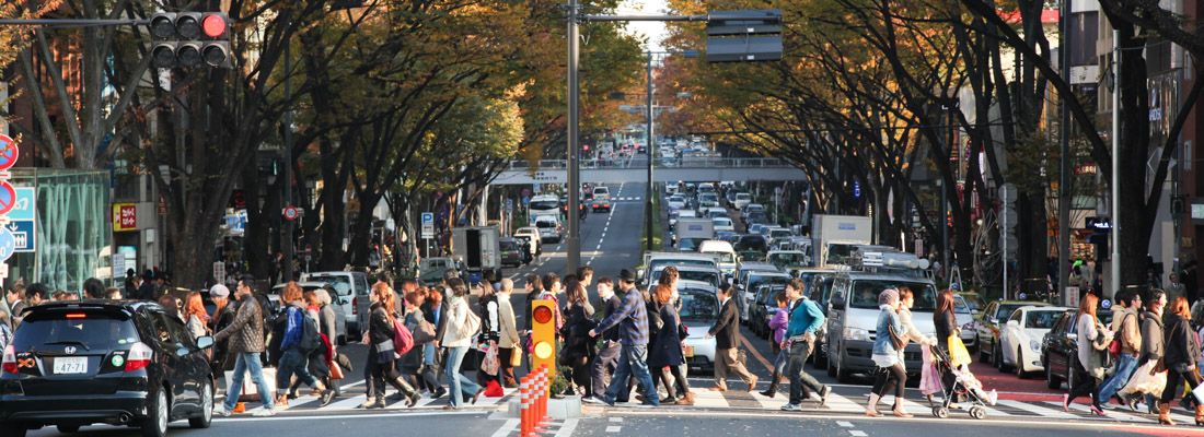 Persone attraversano la strada ad Omotesando.