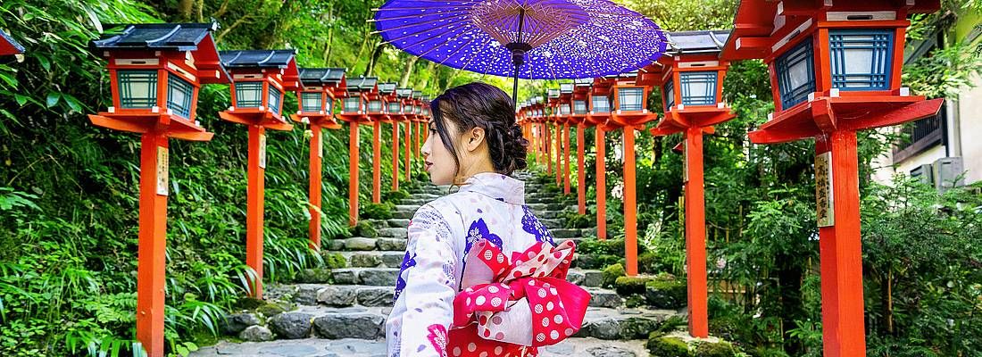 Donna in kimono tenuta per mano, in una zona tradizionale.