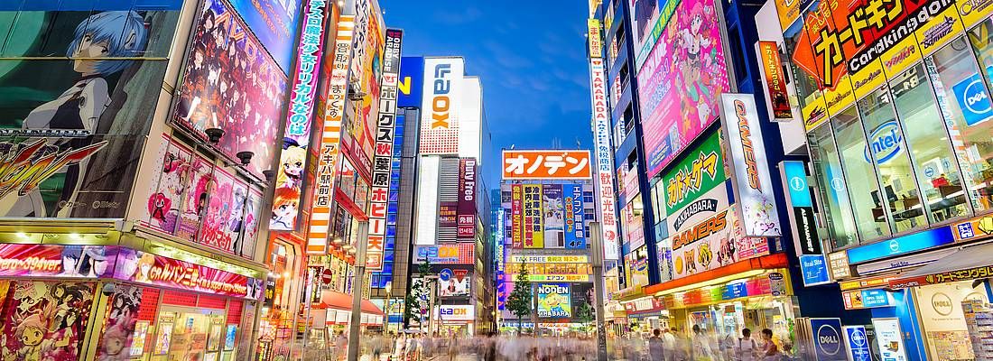 Akihabara di notte, con edifici colorati pieni di riferimenti ad anime e manga.