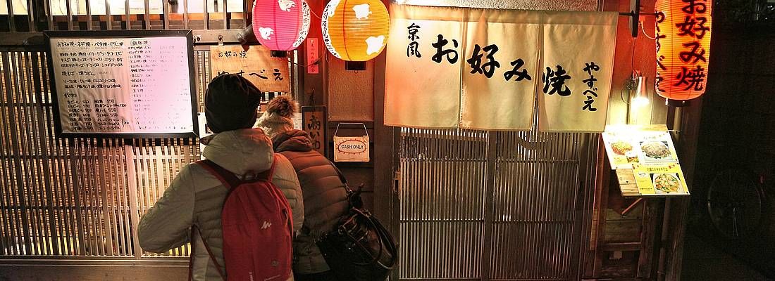 Persone all'ingresso di un ristorante tradizionale a Kyoto.