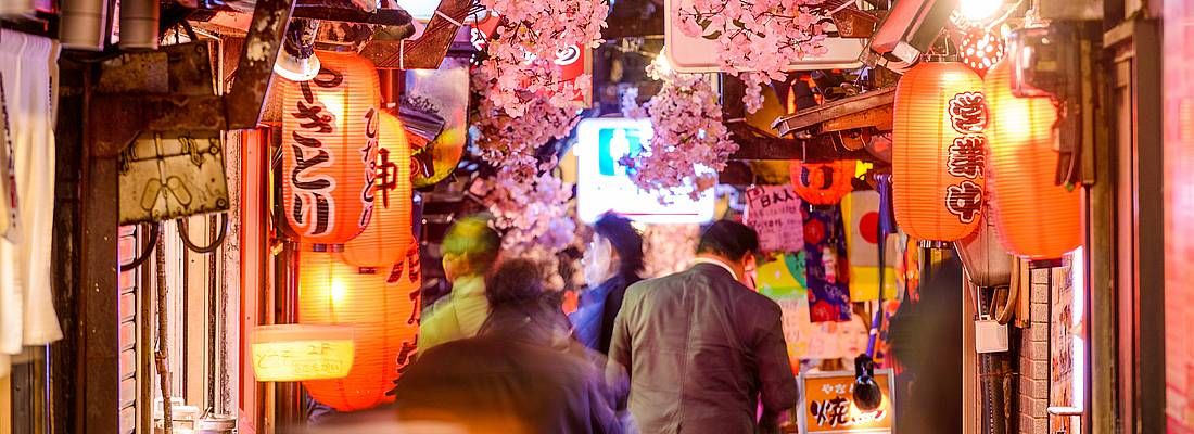 Lanterne tradizionali e persone nella zona di Omoide Yokocho di sera, ricca di ristorantini.