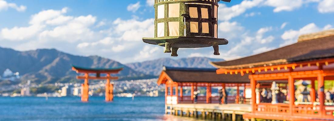 Lanterna al santuario Itsukushima e in lontananza il torii di Miyajima.