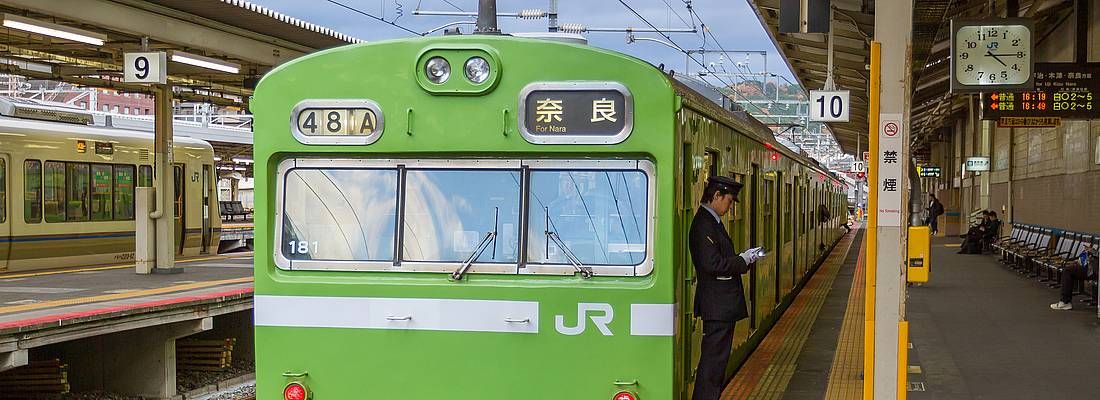 Treno locale JR, di colore verde, diretto a Nara, fermo in stazione a Kyoto.