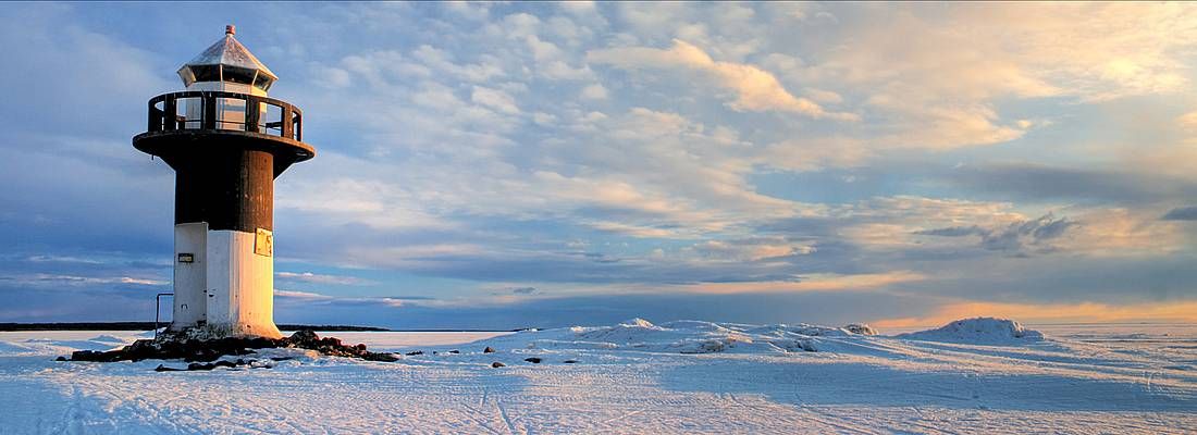 Faro in un paesaggio ghiacciato in Finlandia.