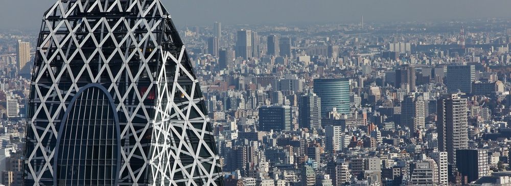 La Cocoon Tower si staglia nel cielo di Tokyo circondata da edifici.