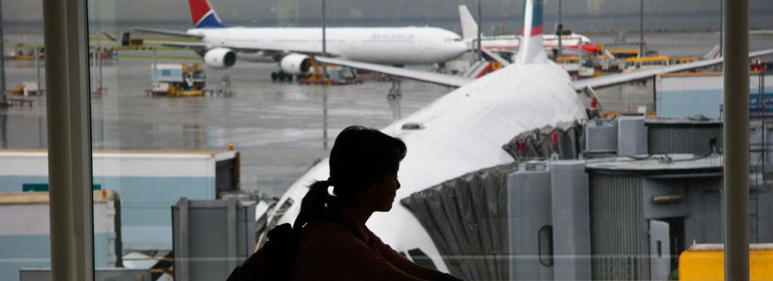 Silhouette di una ragazza in aeroporto, in attesa di imbarcarsi per un volo.