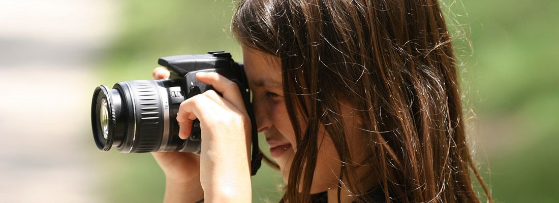 Una bambina fotografa usando una reflex digitale.