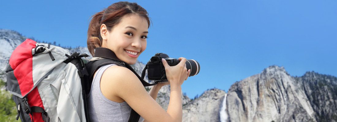 Ragazza fotografa una cascata in un parco naturale.