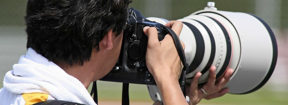 Un fotografo mentre usa un teleobiettivo.