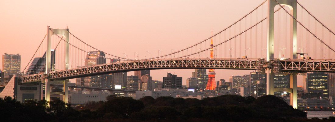 Il Rainbow Bridge di Odaiba al tramonto e sullo sfondo la Tokyo Tower.