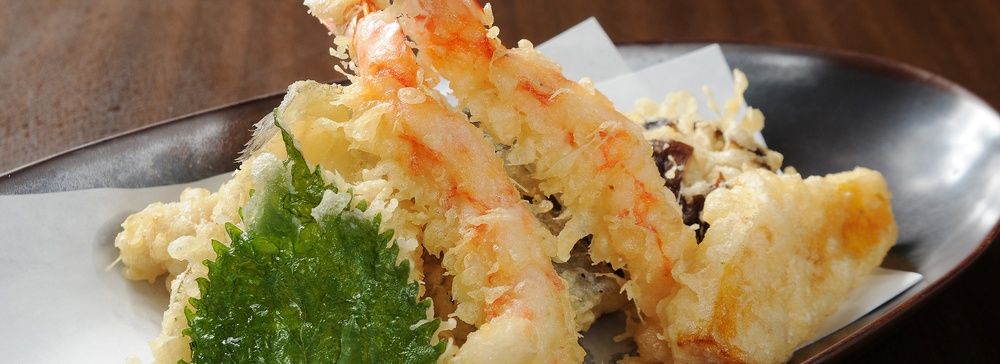 Piatto di tempura con gamberetti croccanti e verdure.