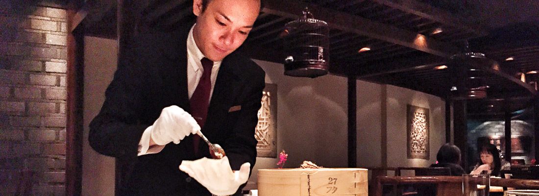 Cameriere cinese molto elegante prepara l'anatra alla cantonese al ristorante Hei Fung Terrace.