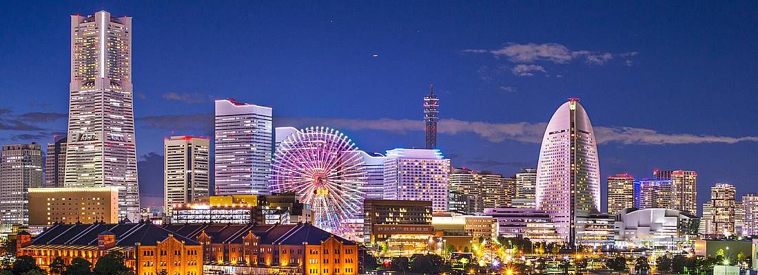 Skyline di Yokohama di sera, con gli edifici illuminati.