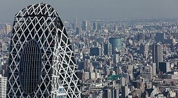 La parte alta della Cocoon Tower in primo piano, e sullo sfondo la città di Tokyo.