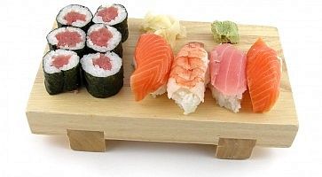 Sushi adagiato su un tradizionale piatto in legno.