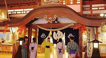 Persone in yukata all'ingresso dell'Oedo Onsen Monogatari.