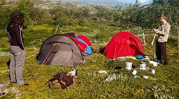 Due campeggiatori montano la tenda in un montagna.