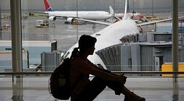 Silhouette di una ragazza in aeroporto, in attesa di imbarcarsi per un volo.