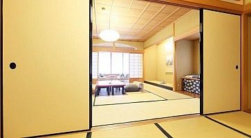 Stanza tradizionale con tatami e porte scorrevoli al Gion Hatanaka Ryokan a Kyoto.