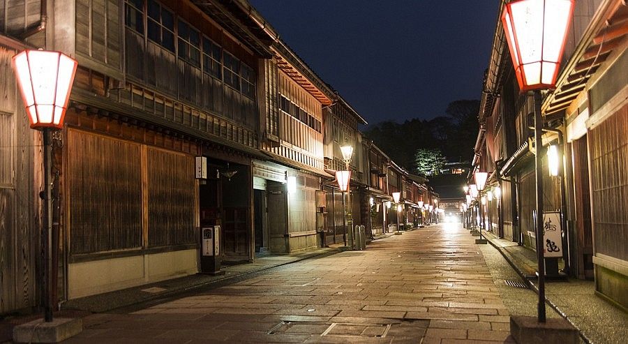 Strada tradizionale illuminata a Kanazawa di sera.