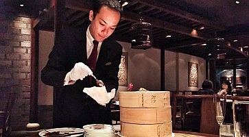 Cameriere cinese molto elegante prepara l'anatra alla cantonese al ristorante Hei Fung Terrace.