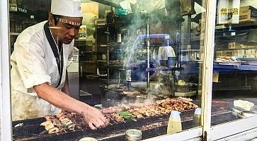 Uno chef intento nella preparazione di spiedini di pollo yakitori.