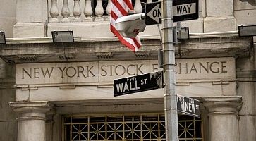 Dettaglio della scritta all'ingresso della Borsa di New York, ed indicazioni stradali che indicano Wall Street.
