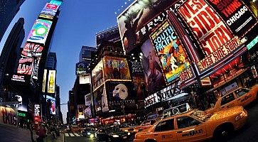 Times Square di notte, ricca di luci, insegne e traffico.
