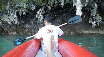 Una canoa si avvicina ad una grotta marina a Phuket.