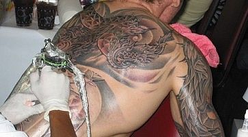 Un uomo si fa tatuare la schiena a Bangkok.