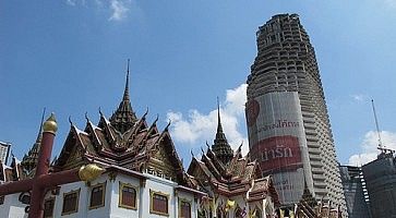 Il grattacielo Sathorn Unique Tower e il vicino tempio.