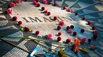 Dettaglio del memoriale Strawberry Fields, con vari fiori appoggiati sulla scritta "Imagine".