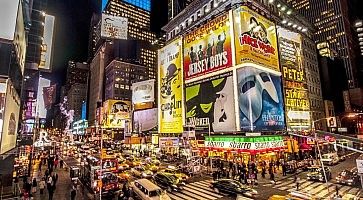 Times Square di sera, con molto traffico e tanta gente.