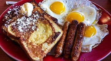 Colazione tipica americana con toast, uova, carne.