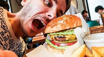 Marco Togni sta per addentare un grande hamburger da Fellows.