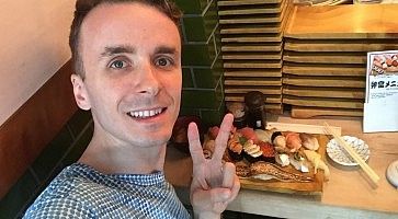 Marco Togni al ristorante di sushi con vassoio di nigiri.