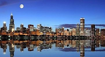 Skyline di una città americana che si specchia sul mare.