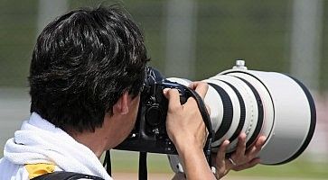 Un fotografo mentre usa un teleobiettivo.
