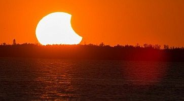 Eclissi parziale di Sole, con il Sole all'orizzonte.