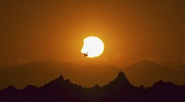Eclissi parziale di Sole., dietro ad alcune montagne.