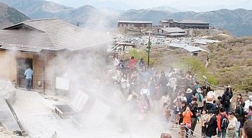 Turisti visitano le fumare della zona vulcanica di Owakudani.