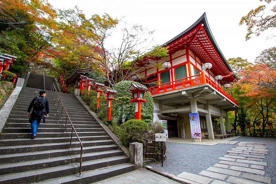 Scalinata verso il tempio Kurama-dera in Giappone, circondato da alberi.