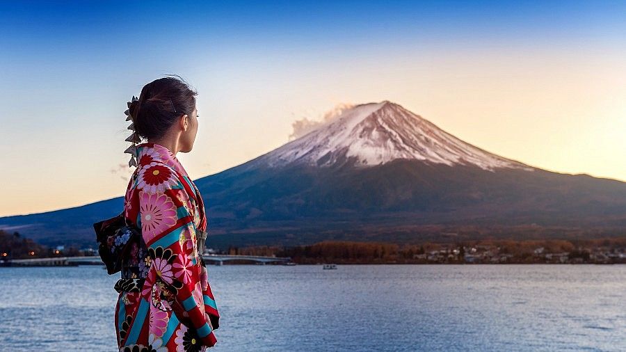 Persona in kimono che osserva il Monte Fuji al tramonto.