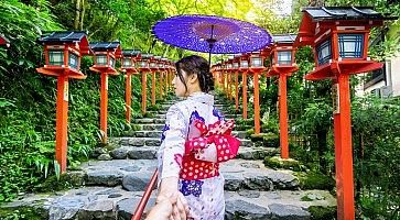 Donna in kimono tenuta per mano, in una zona tradizionale.