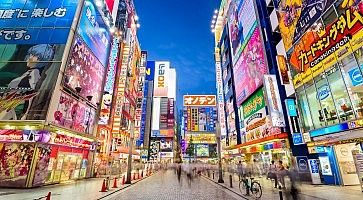 Akihabara di notte, con edifici colorati pieni di riferimenti ad anime e manga.