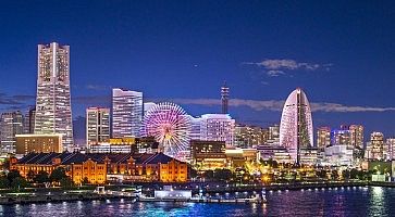 Skyline di Yokohama di sera, con gli edifici illuminati.