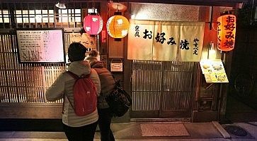 Persone all'ingresso di un ristorante tradizionale a Kyoto.
